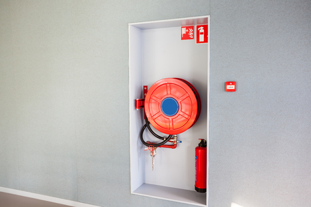 in the hallway of a nice building, there is a fire hoseの写真素材