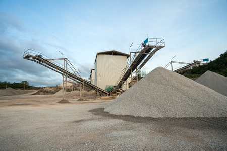 a mountain of sand lies in the concrete factory where and a conveyor belt for transporting the sandの写真素材