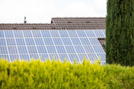 on an building in an residential area, there are solar panels on the roof