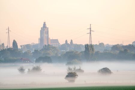 landscape on an early beautiful morning with some misty houses among the housesの写真素材