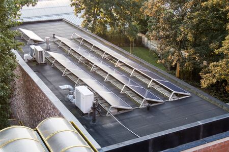 In the city, these solar panels are located on a flat roof of a large building