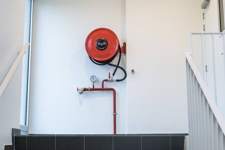 an fire hose hanging on the wall in an staircaseの写真素材