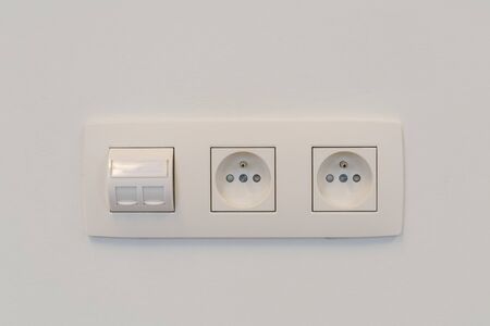 on a white wall, there is a socket with two outlets