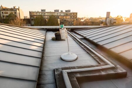 in a big city there is a zinc roof on a high buildingの写真素材