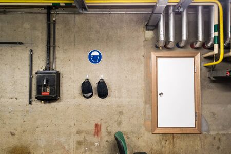 There are two Head Helms on the workplace on the concrete wall in the basement