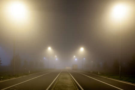 road with street lights on foggy background.の写真素材
