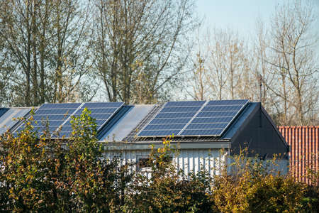 on an building in an residential area, there are solar panels on the roofの写真素材