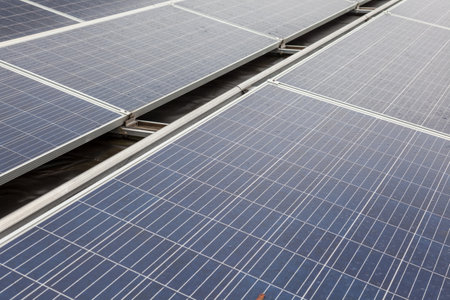on an building in an residential area, there are solar panels on the roof on a cloudy dayの写真素材