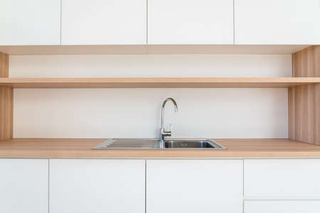 There is a kitchen against the wall in a room of a building