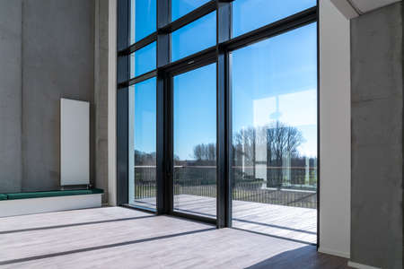 In a large relaxation room with radiator on a concrete wall next to a high windowの写真素材