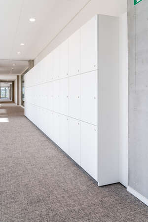 In a long corridor there are storage cupboards along the wallの写真素材