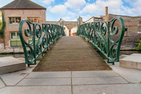 In the city is an wooden bridge over the river whit iron handleの写真素材