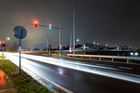 On a rainy dark morning this new Bridge with busy street and traffic lights