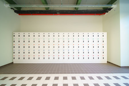 In the corridor of a large building there are small white cupboards