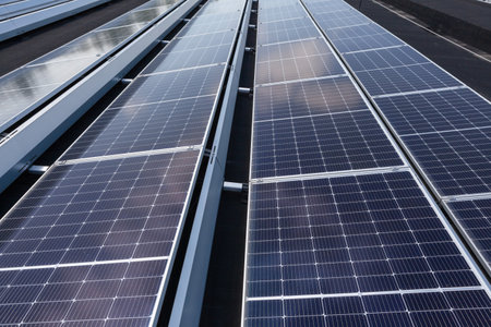 on an building in an residential area, there are solar panels on the roof on sunny dayの写真素材