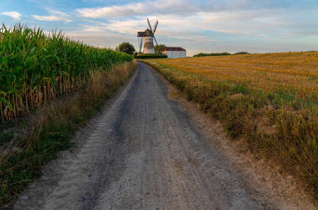 Early in the morning there is a beautiful windmill whit the sun rising in the skyの写真素材