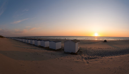 By the sea there is a row of beach huts side by side, whit the sun go downの写真素材