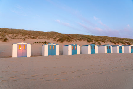 By the sea there is a row of beach huts side by side, whit the sun go downの写真素材