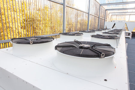 on an flat roof there is cooling air conditioning on an big buildingの写真素材