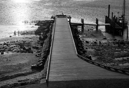 Walkway on the sea where the boat is moored, in black and whiteの写真素材
