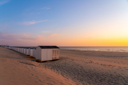 By the sea there is a row of beach huts side by side, whit the sun go downの写真素材