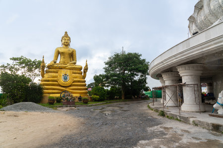 This beautiful Buddha stands in Phuket, Thailand on a cloudy day.の写真素材