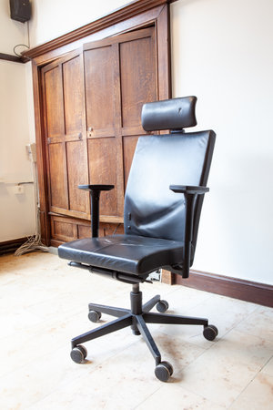 in an old building there is a black office chair in the roomの写真素材