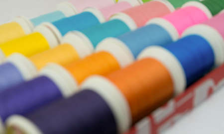 Defocused sewing threads multicolored, blurred background for your designの写真素材
