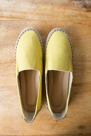 Yellow moccasin shoes on wooden tableの写真素材