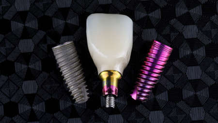 Beautiful composion on different dental implants replica and present with ceramic crown, top view on...