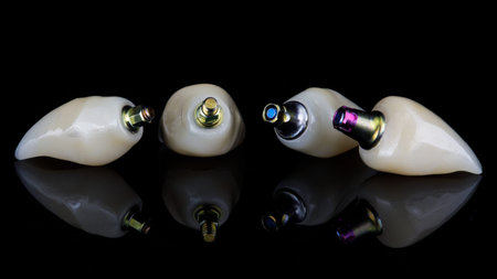 composition of dental four high-quality dental crowns, shot on black glass with reflectionの写真素材