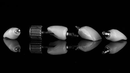 composition of high quality dental crowns on black glass in black and white styleの写真素材