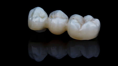 zirconium dental crowns on black glass with reflectionの写真素材