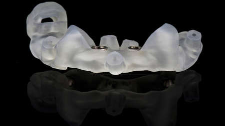 unusual dental template for the integration of dental implants, subject shooting on a black...