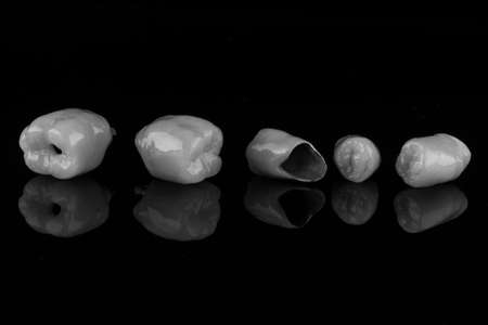 dental crown made of ceramic in black and white style on a black backgroundの写真素材