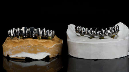 titanium beams on plaster models on a black background