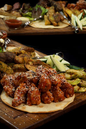 chicken in teriyaki sauce and sesame seeds on a board with reflection on a black backgroundの写真素材