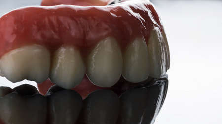 creative photograph of a dental prosthesis of the upper jaw on a mirror with beautiful lighting