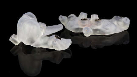 two dental templates for implant surgery of the lower jaw on a black background