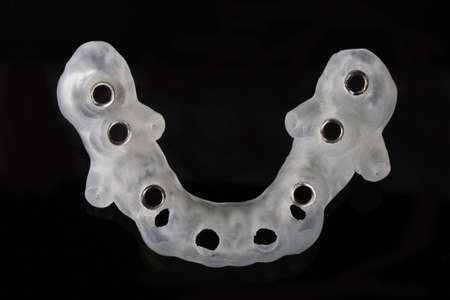 high-tech dental template for six implants, shot from above on a black background