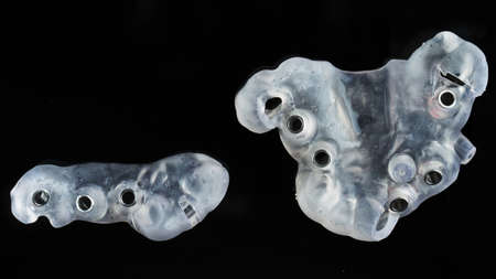 two special surgical templates for implantation on black glass, shot from aboveの写真素材