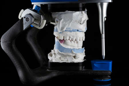 Dental articulator and jaw model, side view on black backgroundの写真素材
