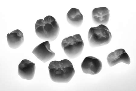 Creative frame of the set of ceramic crowns on a white background, shot in black and white style