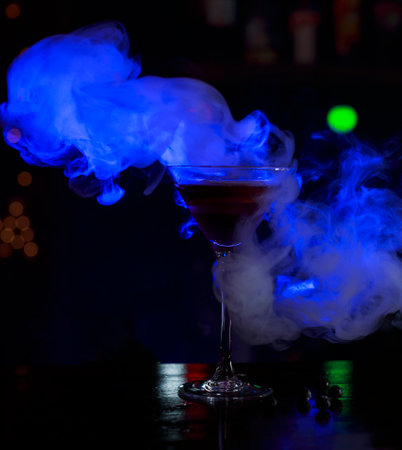 drink with blue smoke and berries on the barの写真素材