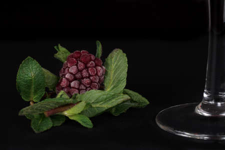 frozen blackberries on mint leaves before adding to cocktail glass
