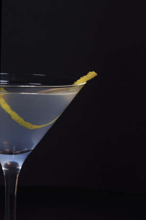 white lady cocktail with zest for taste, shot in an interesting perspective on a half glass on a...