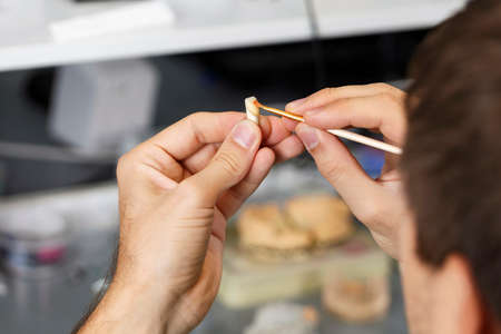 dental technician works with shades of ceramic crownsの写真素材