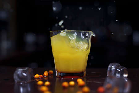 bright yellow drink with sea buckthorn berries and ice