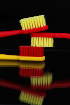 Toothbrushes on a black background with reflection, close upの写真素材