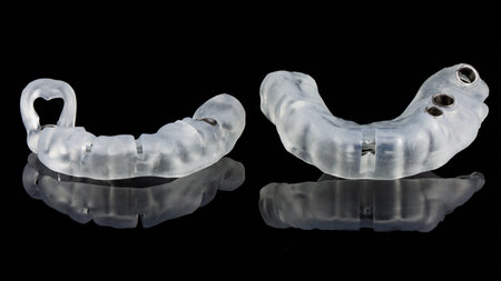 two high-quality dental templates for implantation in different areas of the jaw on a black backgroundの写真素材